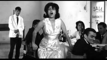     
    Il corpo performativo di Anna Magnani durante la battaglia degli stornelli in Mamma Roma di P.P. Pasolini, 1962