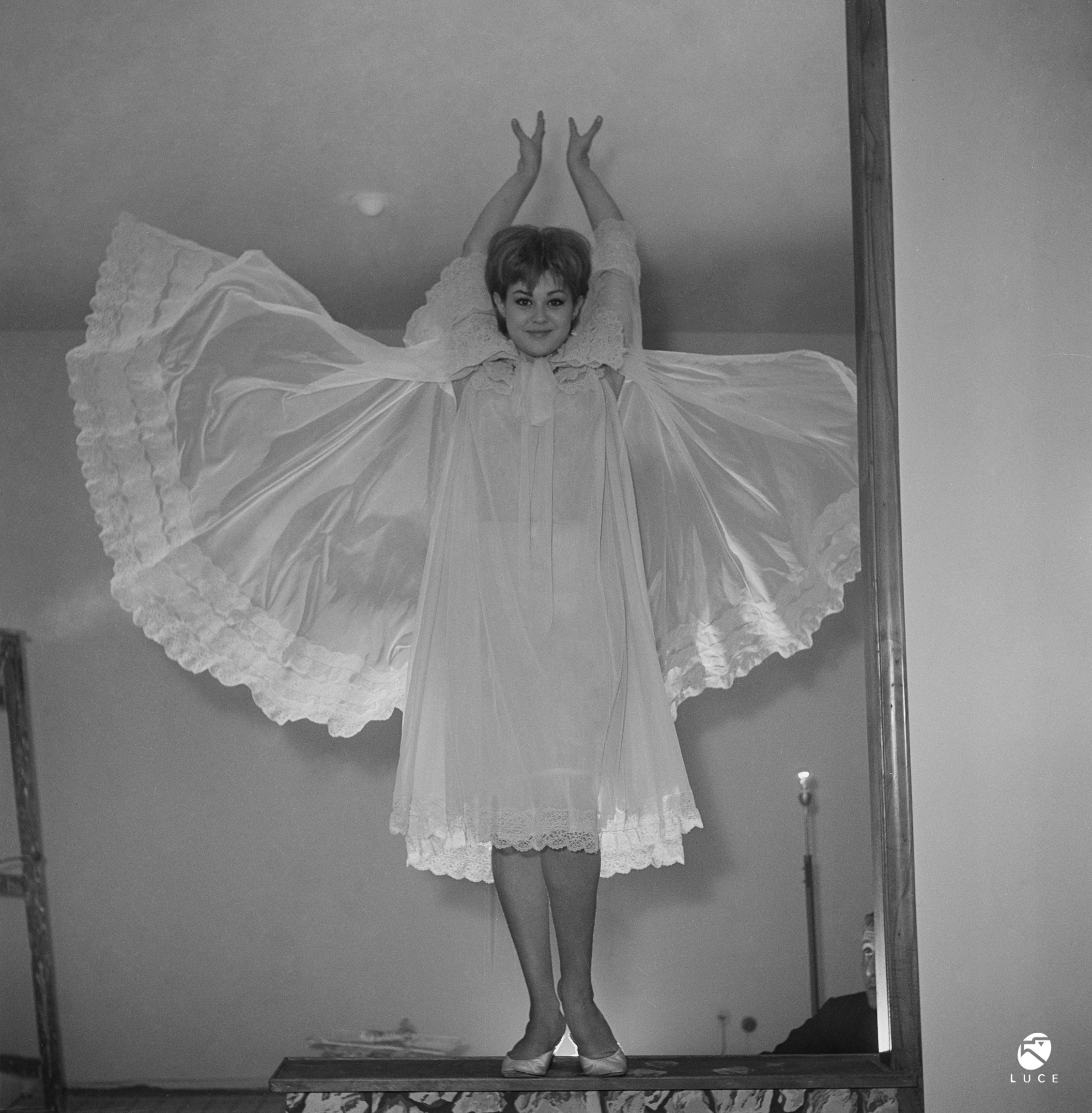 Fig. 5 Vicky Ludovisi gioca con i lembi della sua vestaglia, 1961, Materiale fotografico Archivio Storico Istituto Luce Cinecitt&agrave;.
