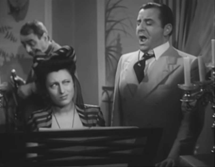 Fig.5| Anna Magnani al pianoforte nel salotto de La vita &egrave; bella (1943) [Screenshot da terzi del film]
