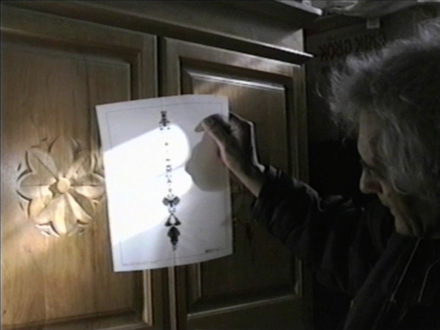 Alberto Grifi mostra uno schiacciaparole di Giordano Falzoni (Screenshot da terzi del film Autobiografia di una casa, 2002).
