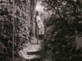 Grazia incinta e sorridente passeggia tra i fiori del grande giardino di casa Lenzi. Fondo Giuseppe Lenzi, HMLENZGIU-0043, 8mm, 1970, conservato presso Home Movies &ndash; Archivio Nazionale del Film di Famiglia.
