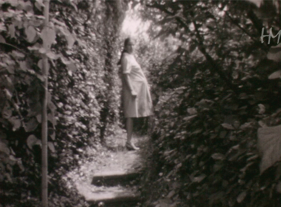 Grazia incinta e sorridente passeggia tra i fiori del grande giardino di casa Lenzi. Fondo Giuseppe Lenzi, HMLENZGIU-0043, 8mm, 1970, per gentile concessione di Home Movies–ArchivioNazionale del Film di Famiglia