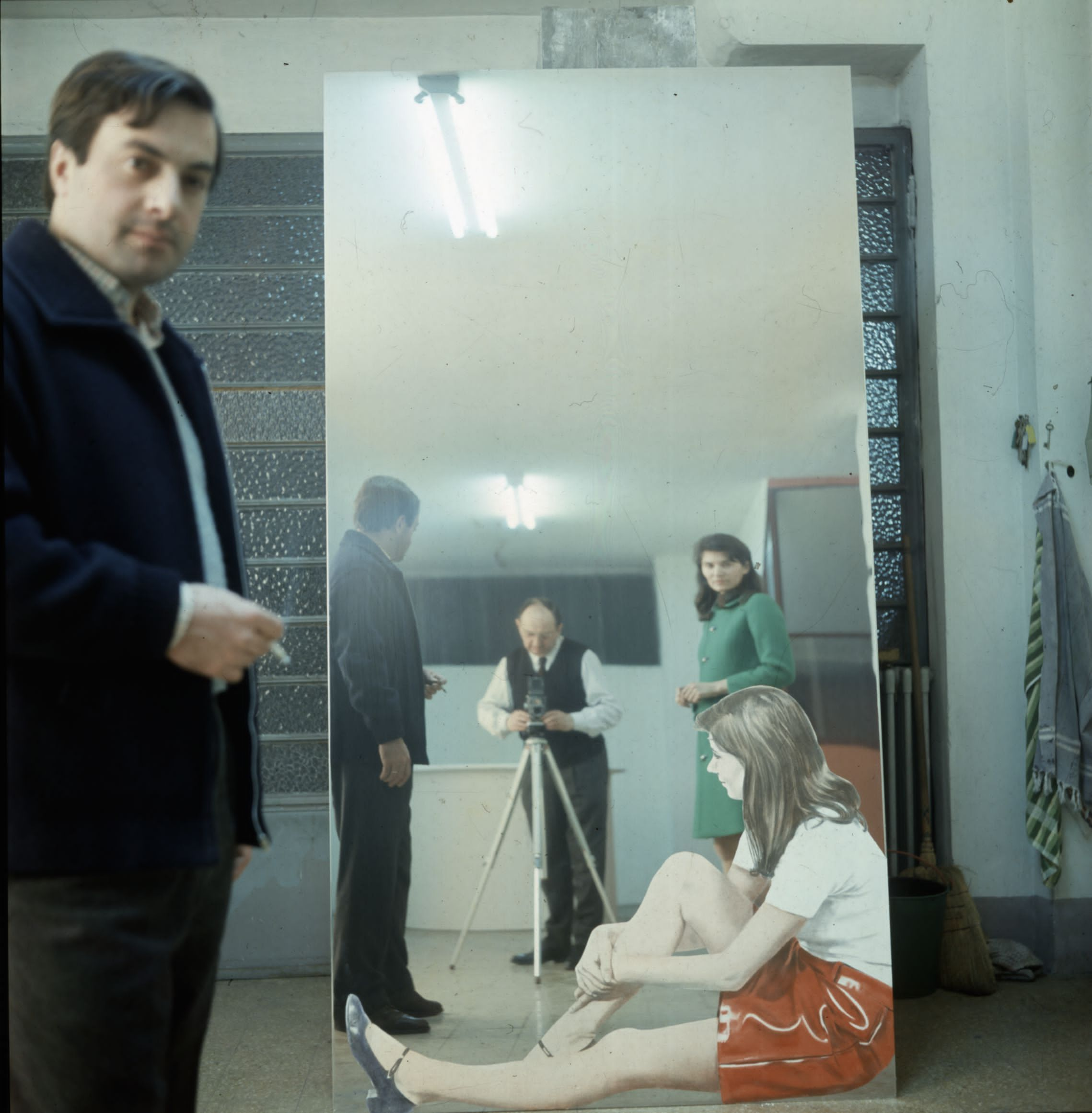 Paolo Bressano, Studio di Pistoletto a Torino, 1967. In piedi sulla sinistra l’architetto Pietro Derossi, progettista e gestore del Piper. Rilesso nel quadro specchiante ragazza seduta per terra, De Rossi, il fotografo Paolo Bressano e Graziella Gay Derossi, soggetto dell’opera