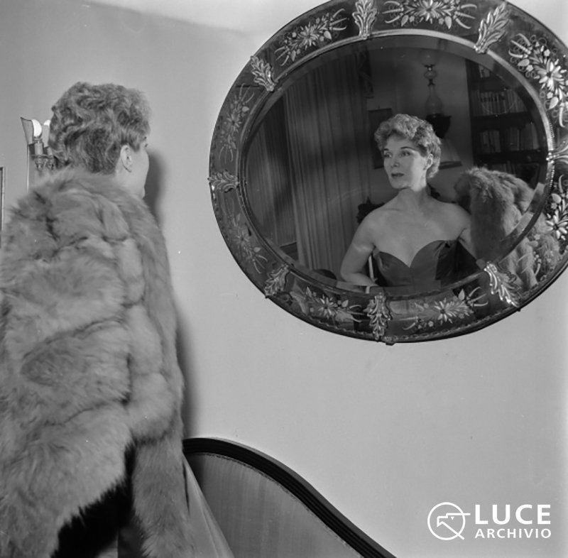 Elsa de’ Giorgi riflessa in uno specchio ovale nel suo appartamento s.d. ©Archivio Storico Istituto Luce Elsa de’ Giorgi riflessa in uno specchio ovale nel suo appartamento s.d. ©Archivio Storico Istituto Luce